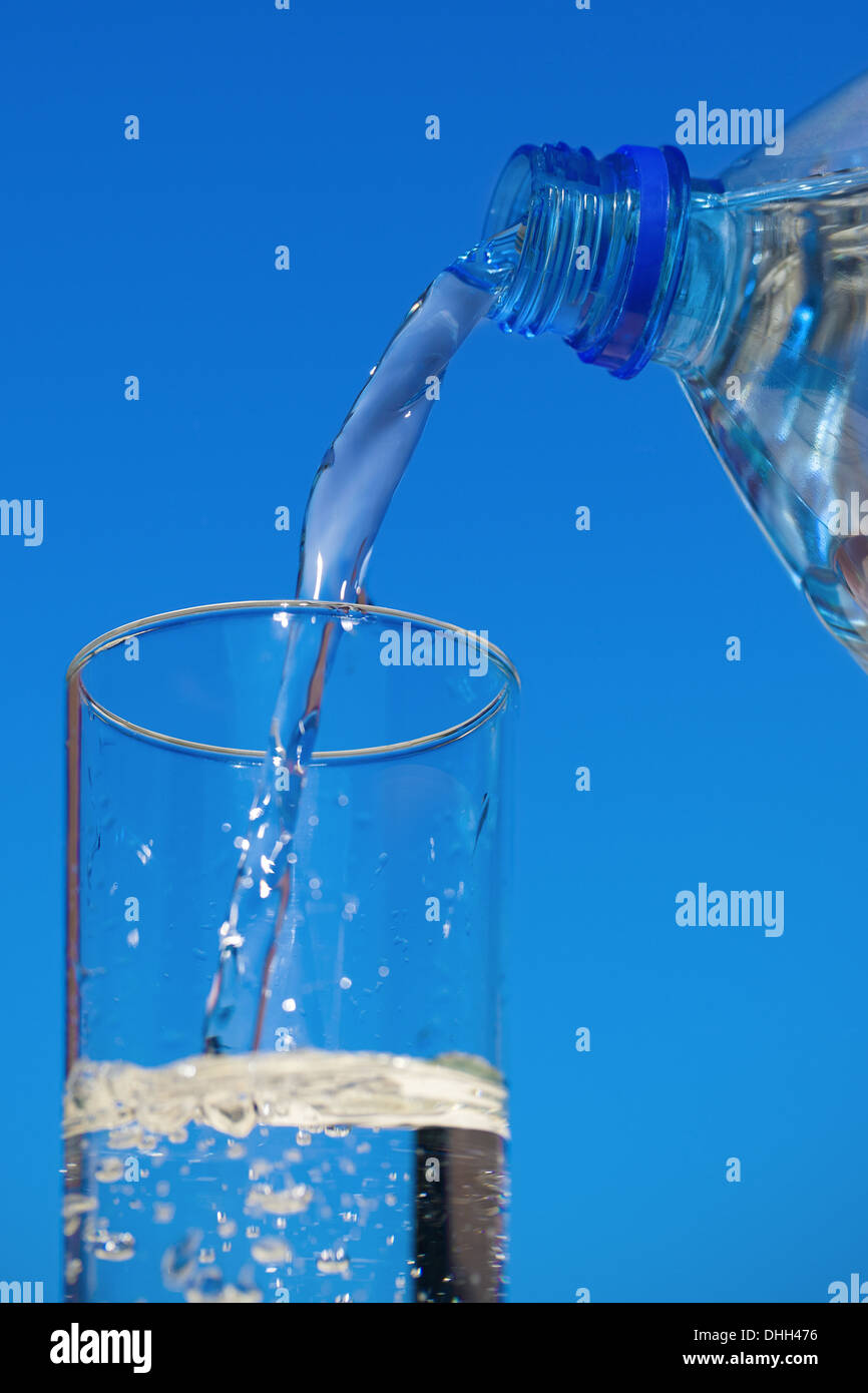 Water flows from bottle into a glass Stock Photo