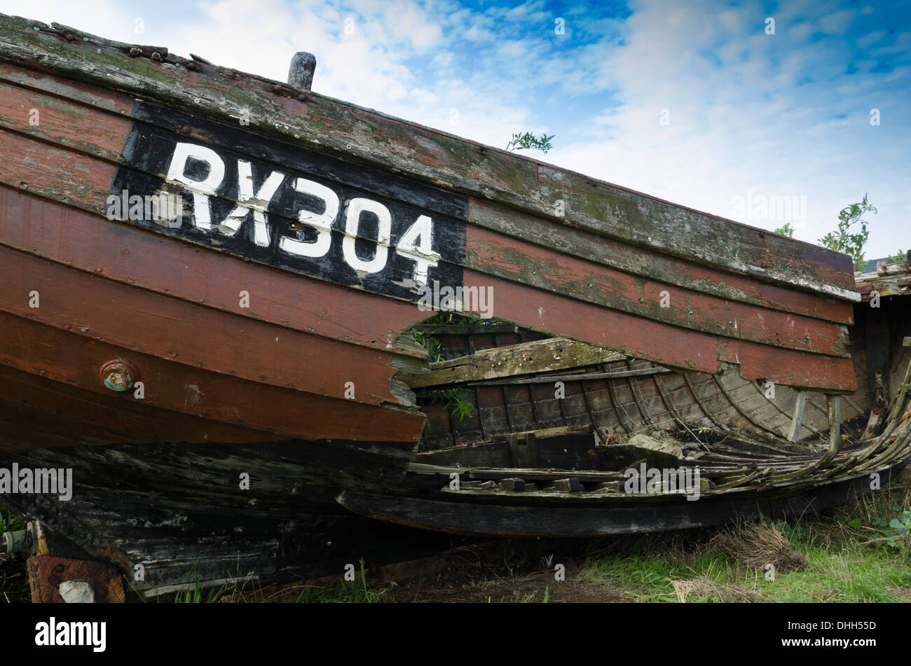 An old fishing boat with a large hole in the side Stock Photo Alamy