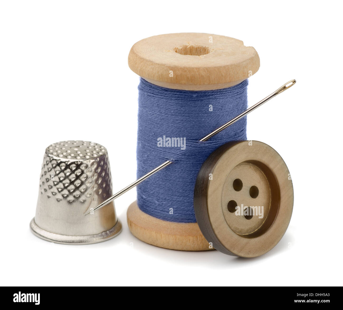 Spool of blue thread, needle, button and thimble isolated on white Stock Photo