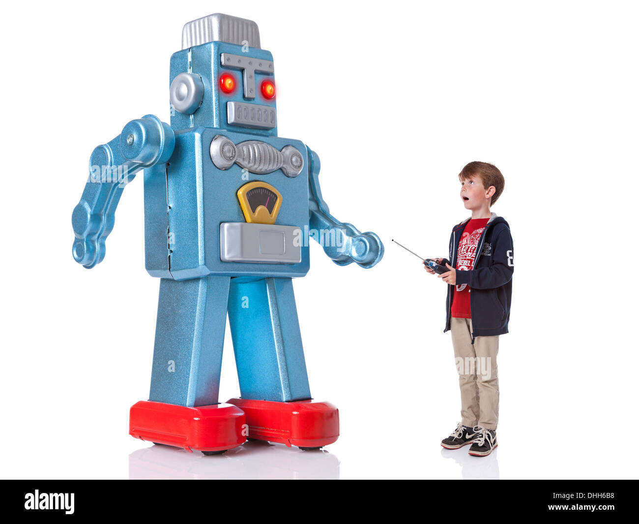 A young boy controlling a giant mechanical robot, isolated on a white background. Stock Photo