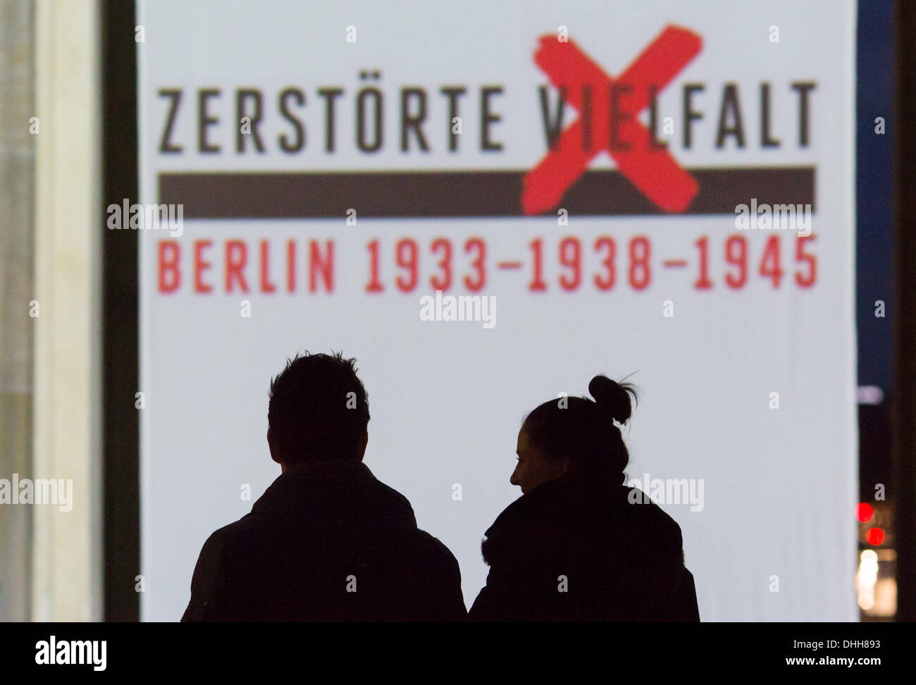Berlin, Germany. 10th Nov, 2013. A silhouetted couple walks past a projection on the Brandenburg Gate in Berlin, Germany, 10 November 2013. The theme year 'Destroyed diversity - 1933 - 1938 - 1945' ends with the projection of video works by youths, portraits of persecuted artists during the Nazi regime, talks with contemporary witnesses and concerts at Pariser Platz in Berlin, Germany, 10 November 2013. Photo: Florian Schuh/dpa/Alamy Live News Stock Photo