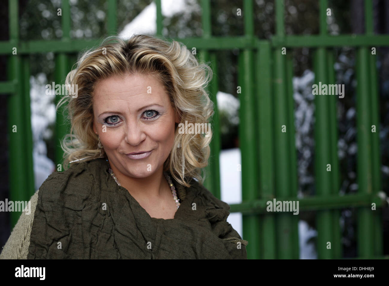 blond woman in a green coat Stock Photo