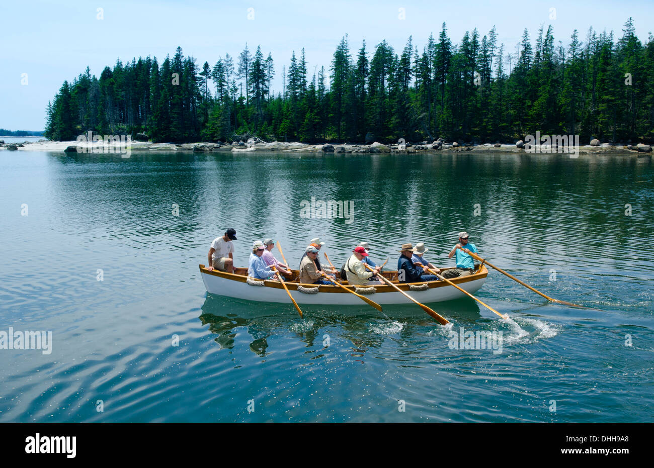 Maine Rowing Maine summer passengers rowing small boat to beach from bigger sailboat ...