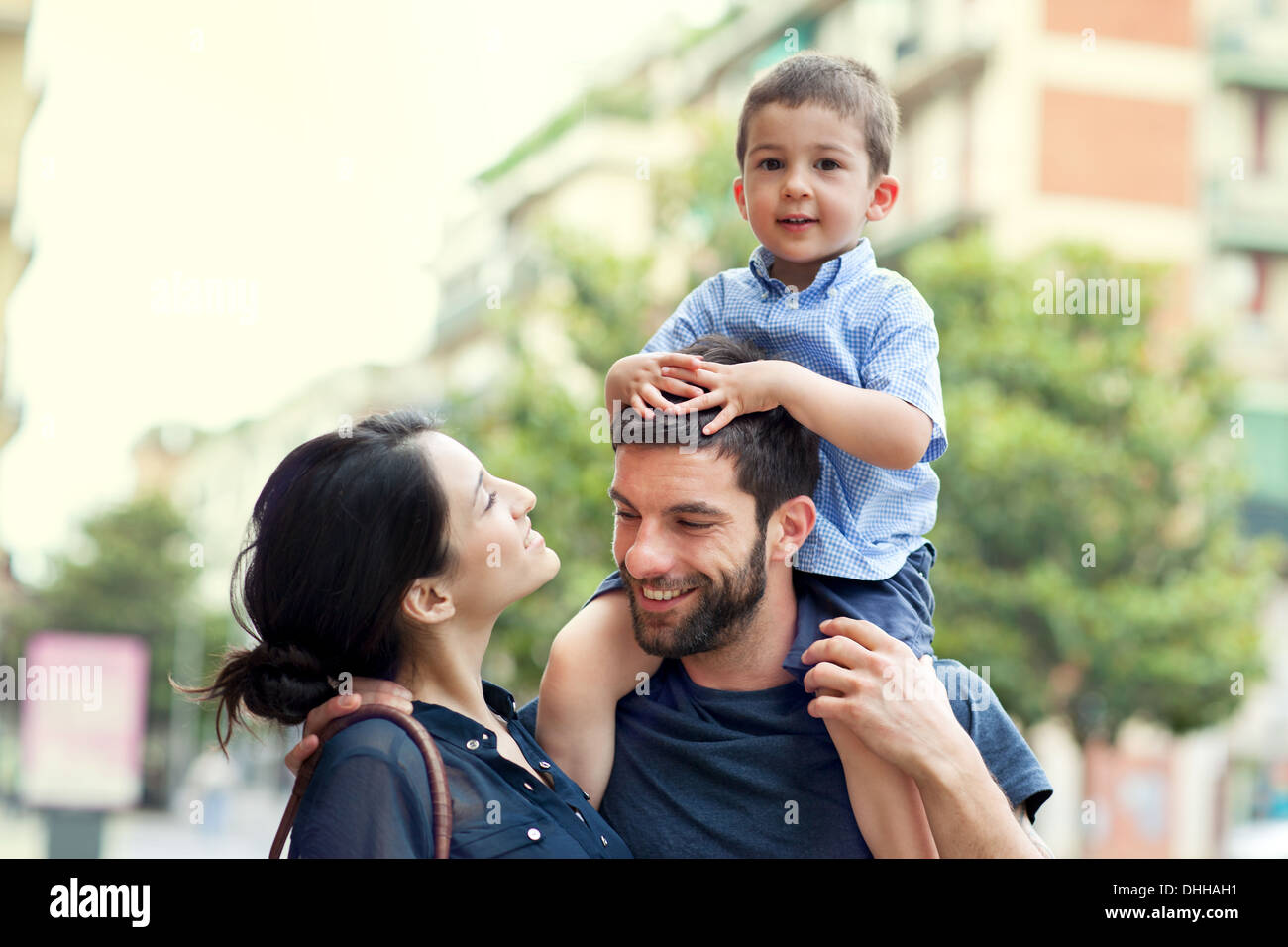 Father carrying son on shoulders with woman Stock Photo