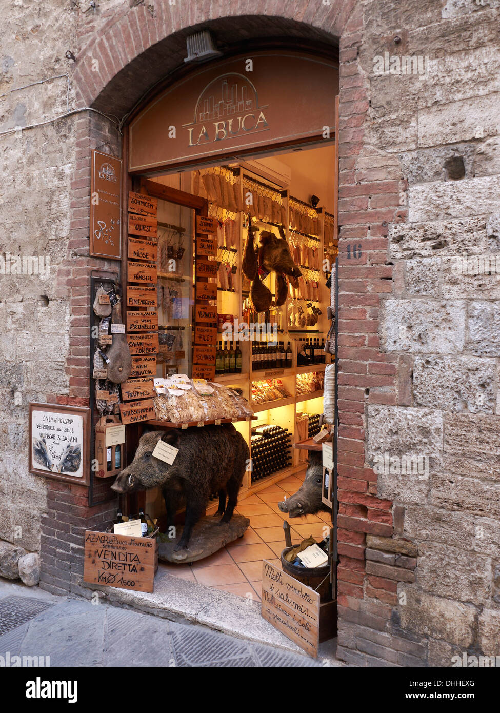 A Shop selling local specialities in San GimignanoTuscany Italy including wines cheeses and local meats. Decorated with a stuffed wild boar Stock Photo