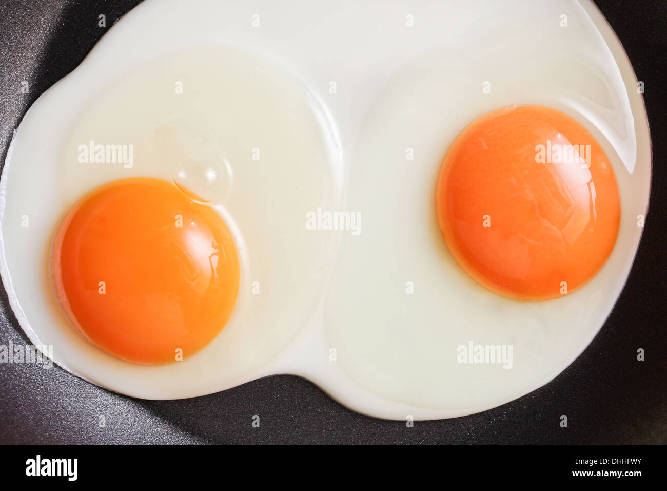 Two fresh eggs being fried in a nonstick pan Stock Photo Alamy