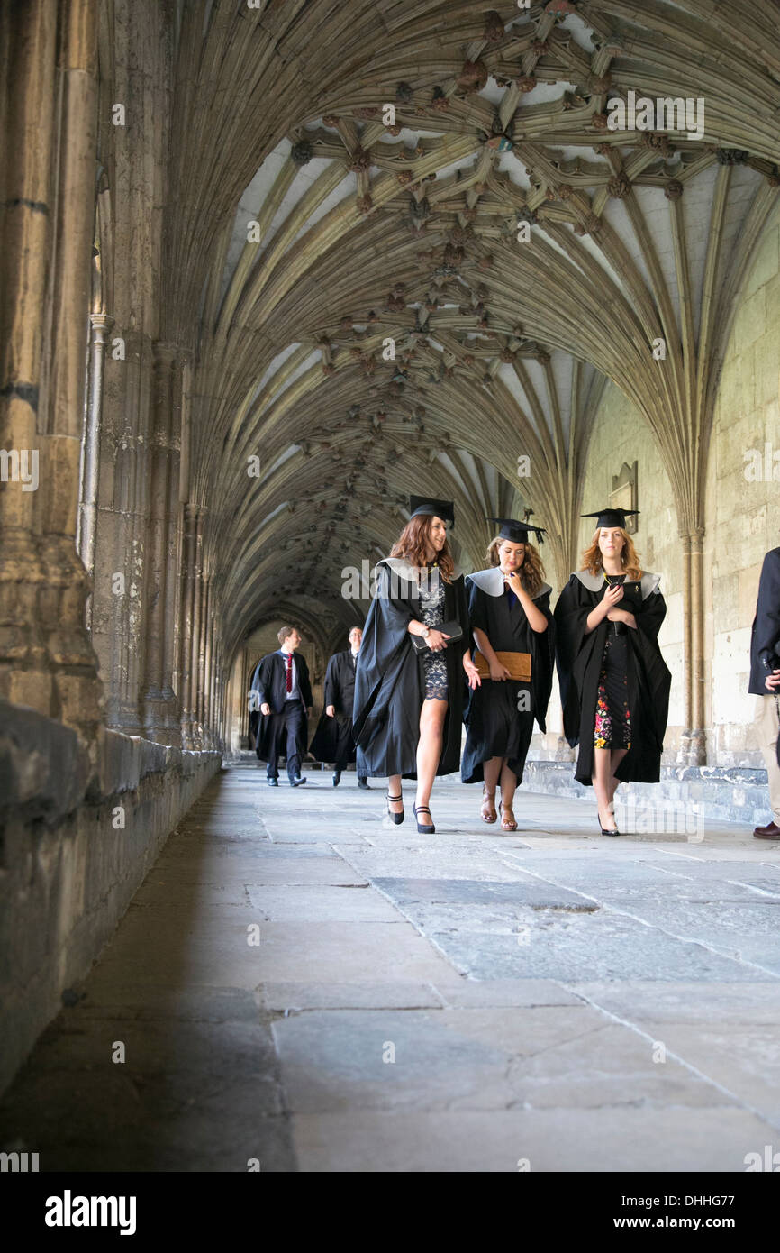 Robed university graduates walking through the cloisters at Canterbury Cathedral, Kent, UK on their way to graduation ceremony Stock Photo