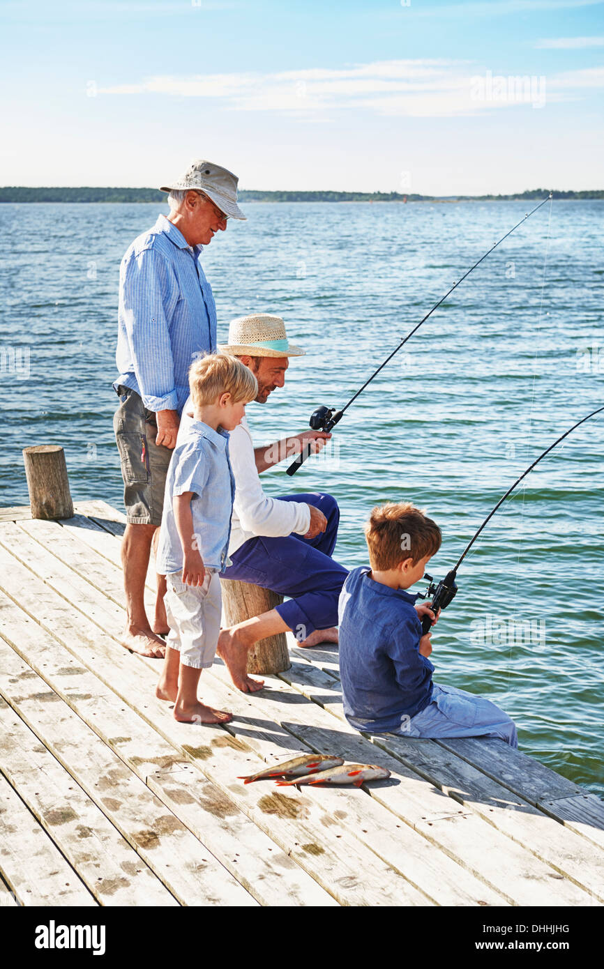 Boys with father and grandfather fishing, Utvalnas, Sweden Stock Photo