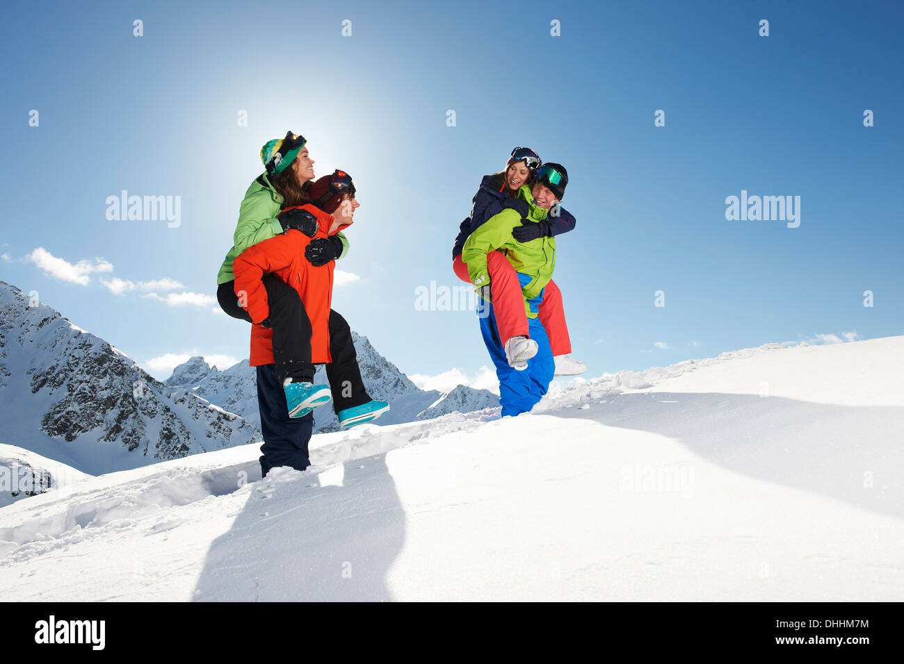 Friends giving piggy backs in snow, Kuhtai, Austria Stock Photo