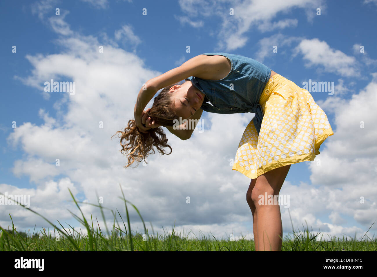 Teenage girl bending forward with hands in hair Stock Photo