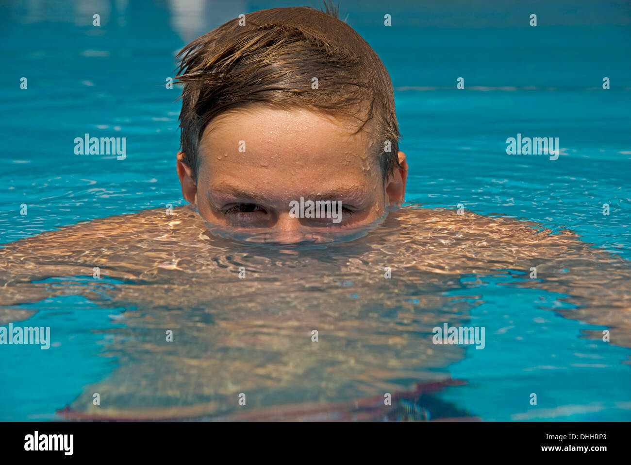 Young emerges from the water in a swimming pool Stock Photo