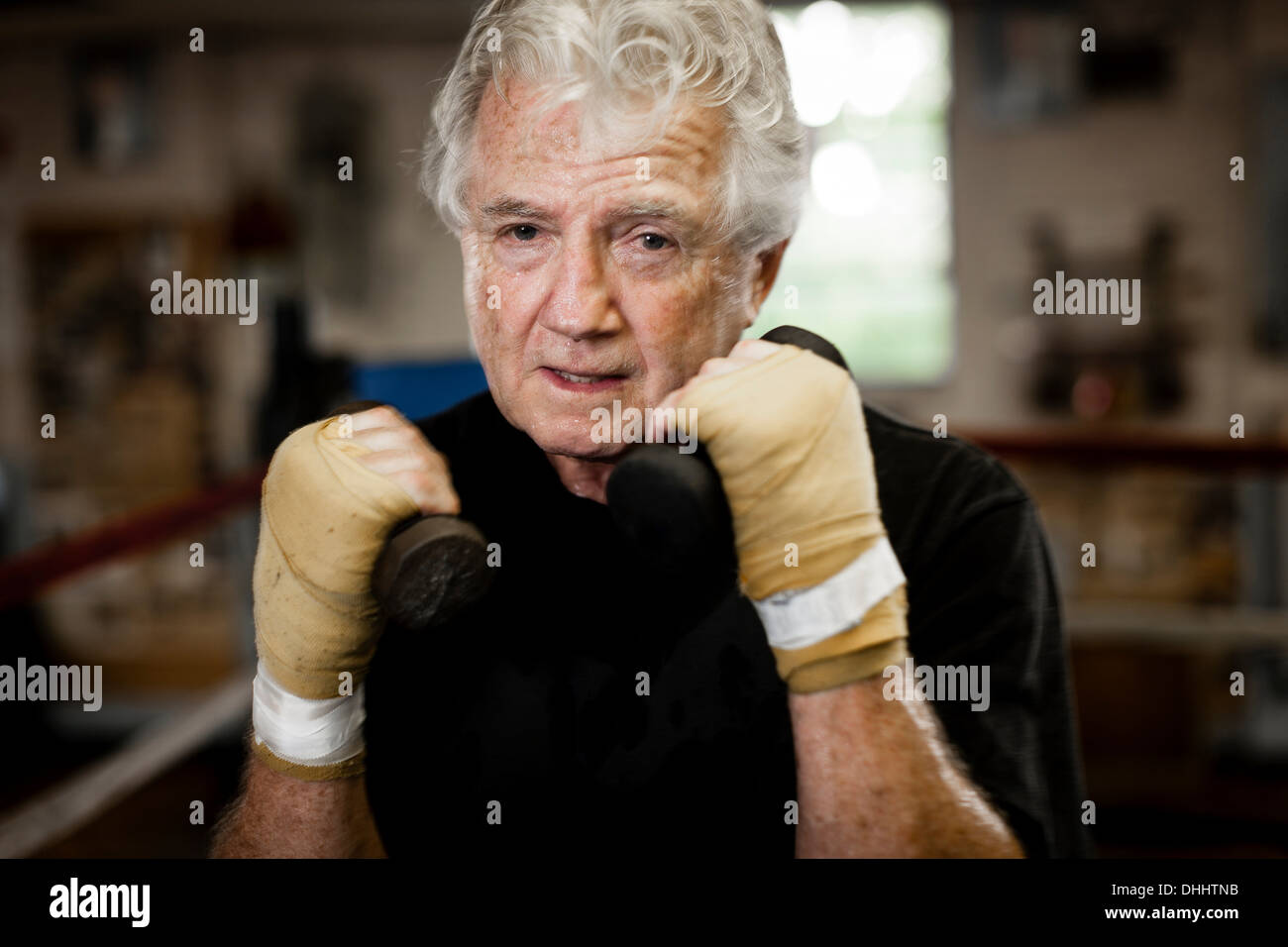 Senior man wearing gloves lifting hires stock photography and images