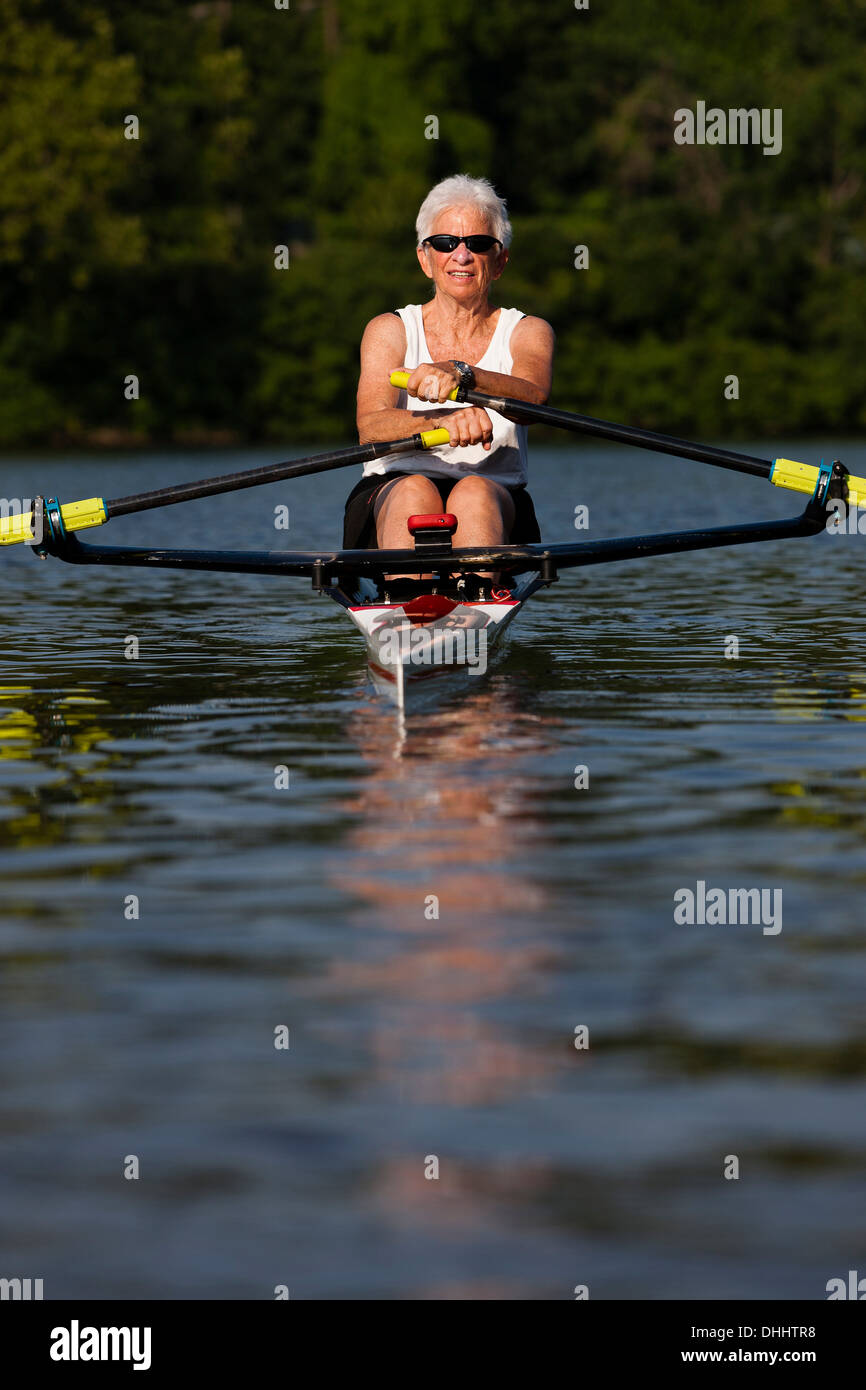 Senior woman rowing in rowing boat Stock Photo