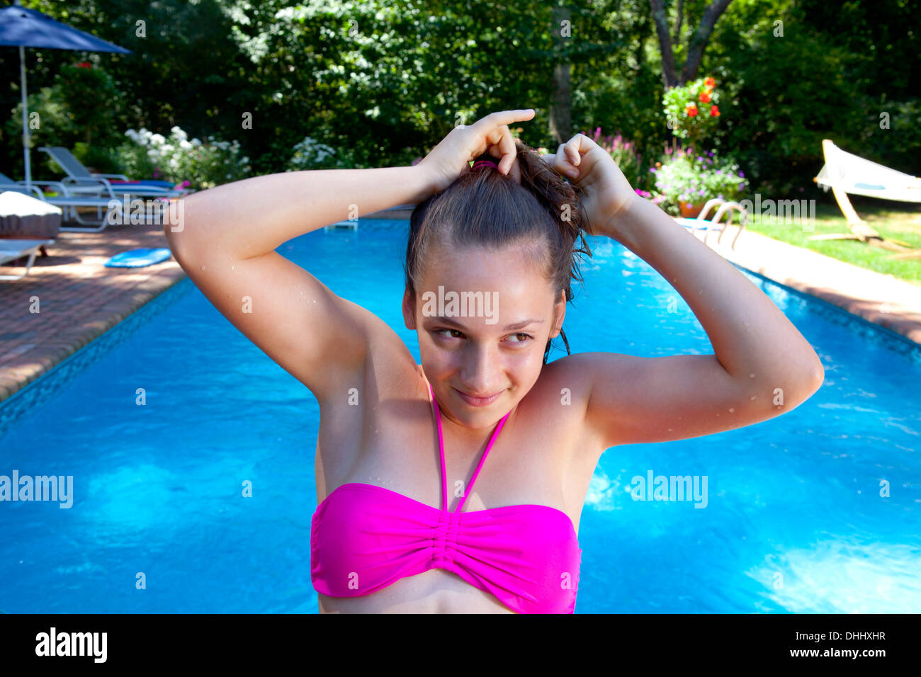 Girl tying hair by pool Stock Photo
