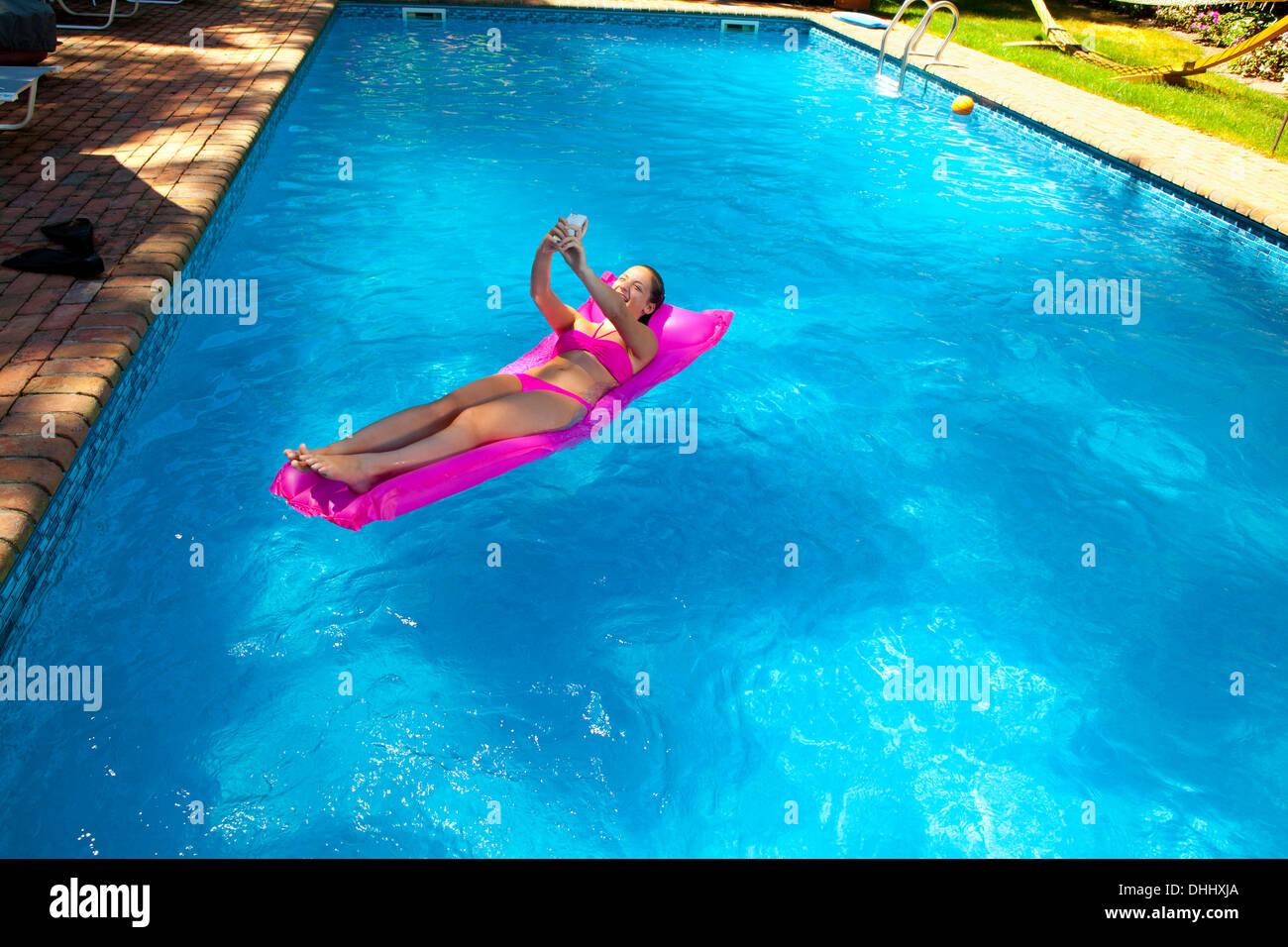 Girl on inflatable bed in pool Stock Photo