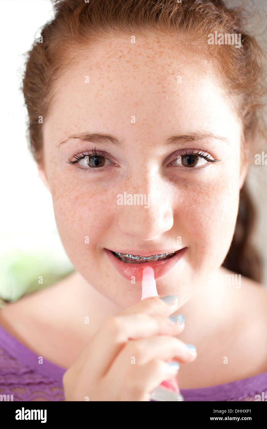 Girl applying lip gloss Stock Photo