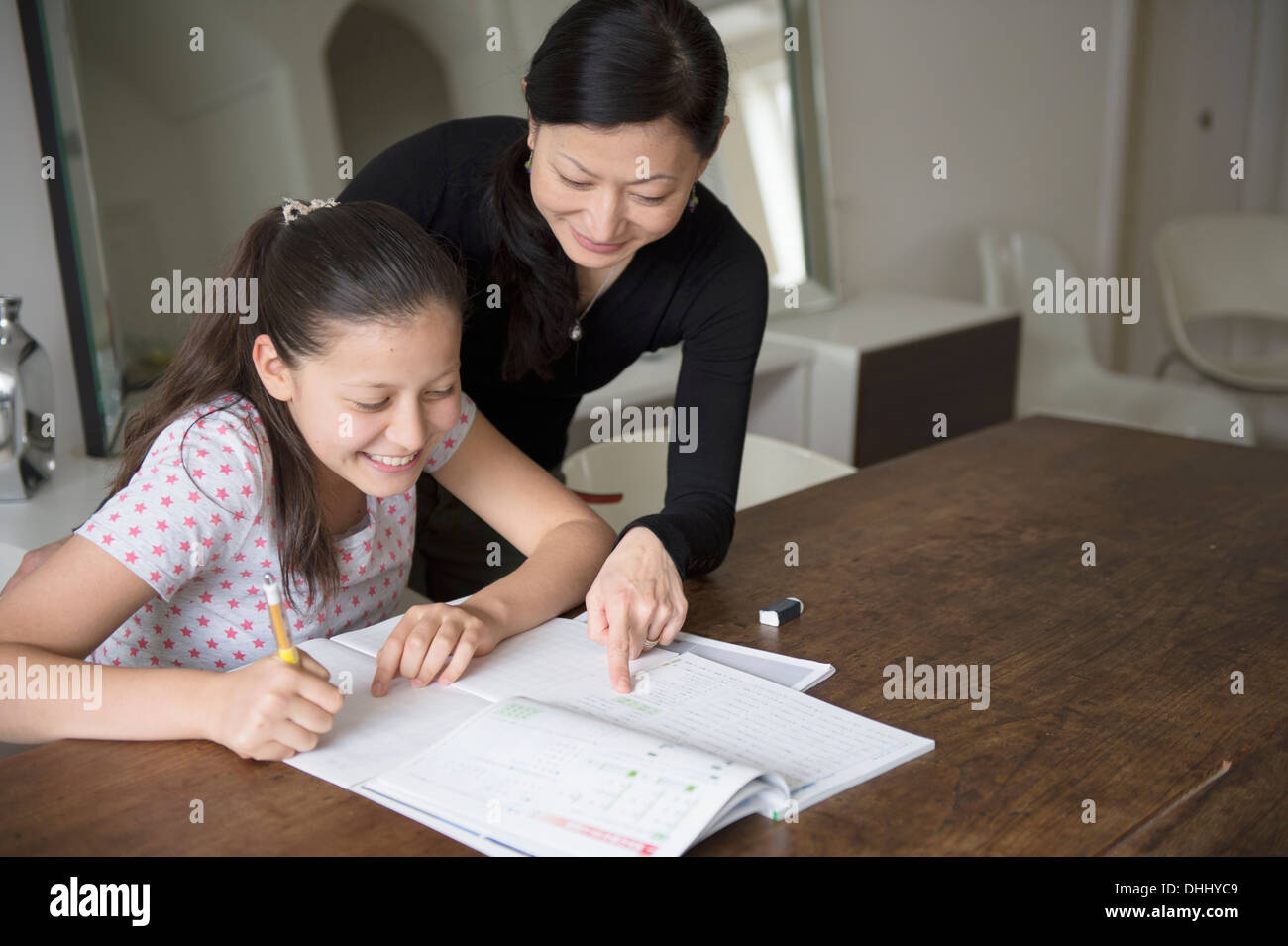 Mother helping teenage daughter with homework Stock Photo