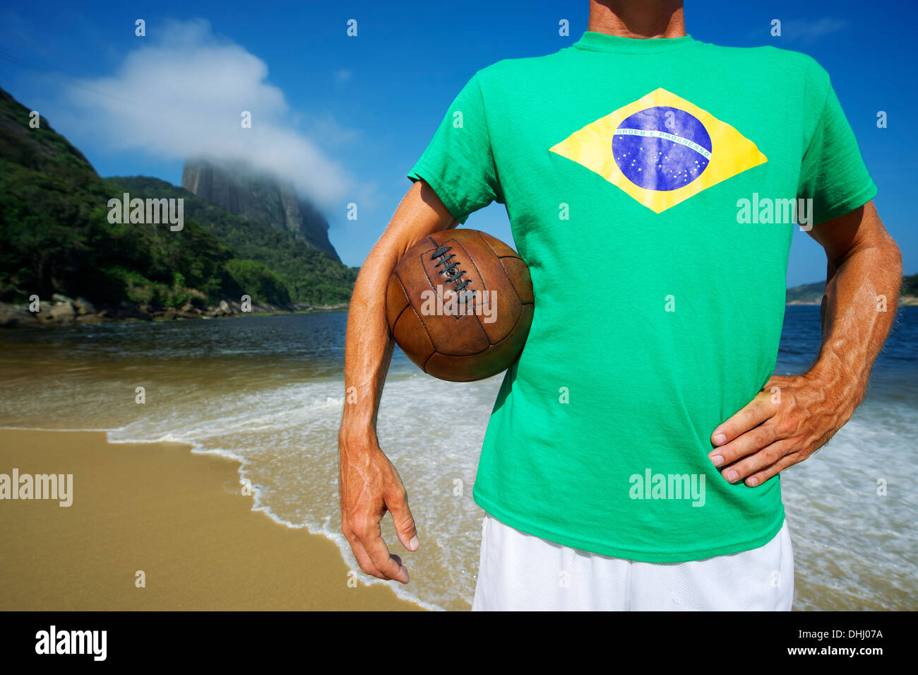 Brazilian soccer player stands with old football at Sugarloaf Pao de Acucar in Rio de Janeiro Brazil Stock Photo
