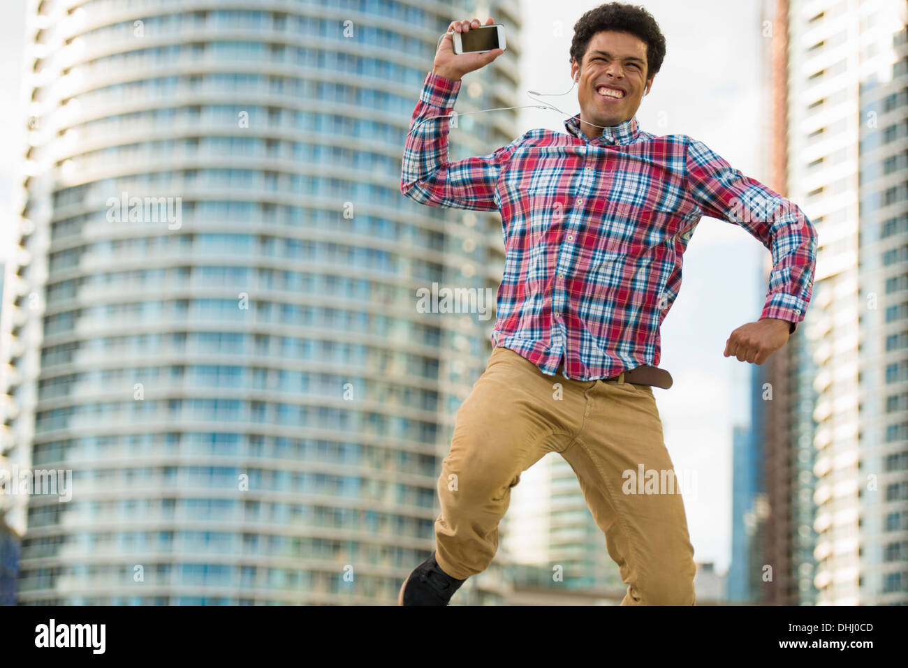 Man with mobile phone jumping for joy Stock Photo - Alamy