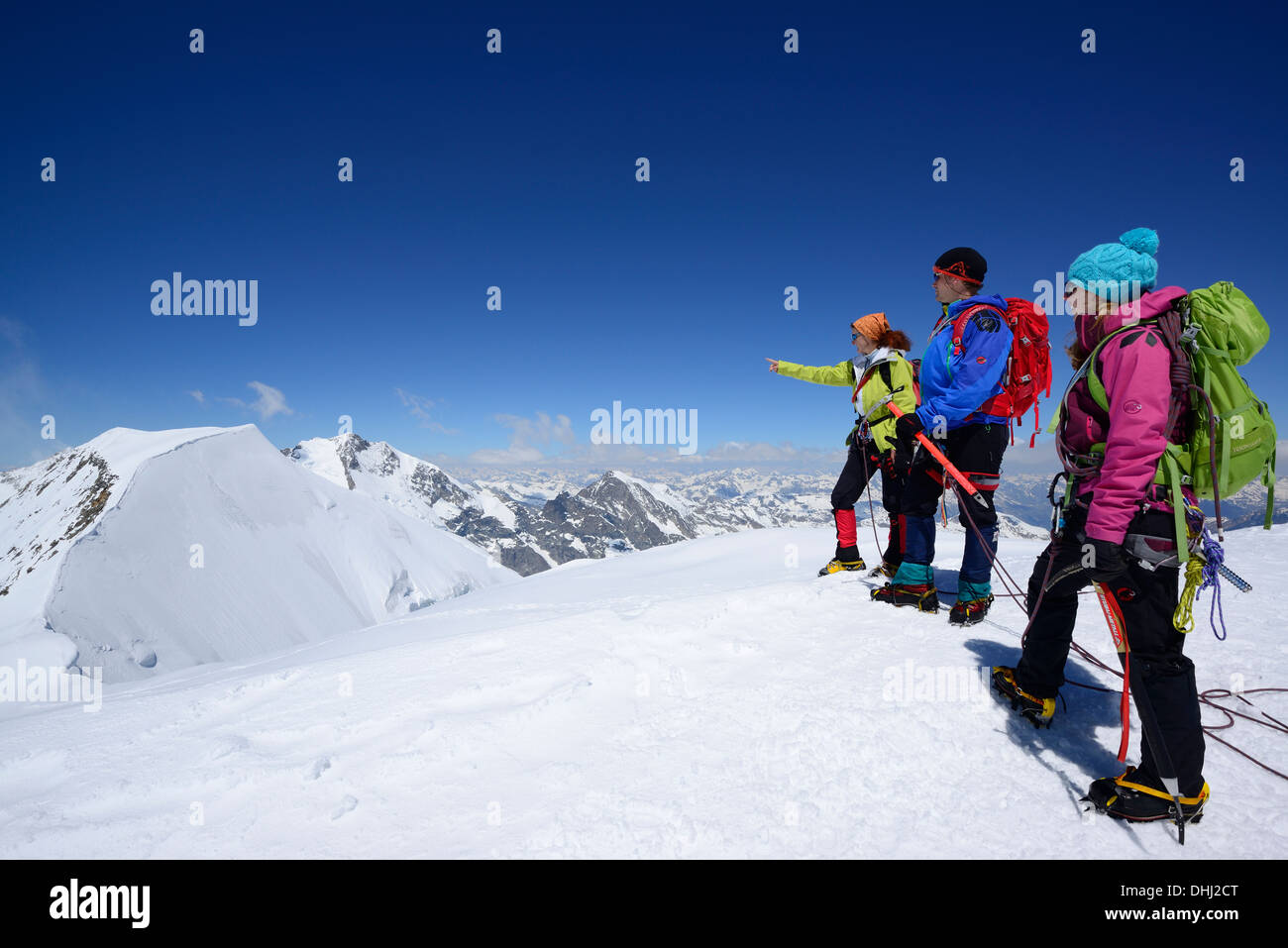 Three mountaineers standing on top of Piz Palue, Grisons, Switzerland Stock Photo