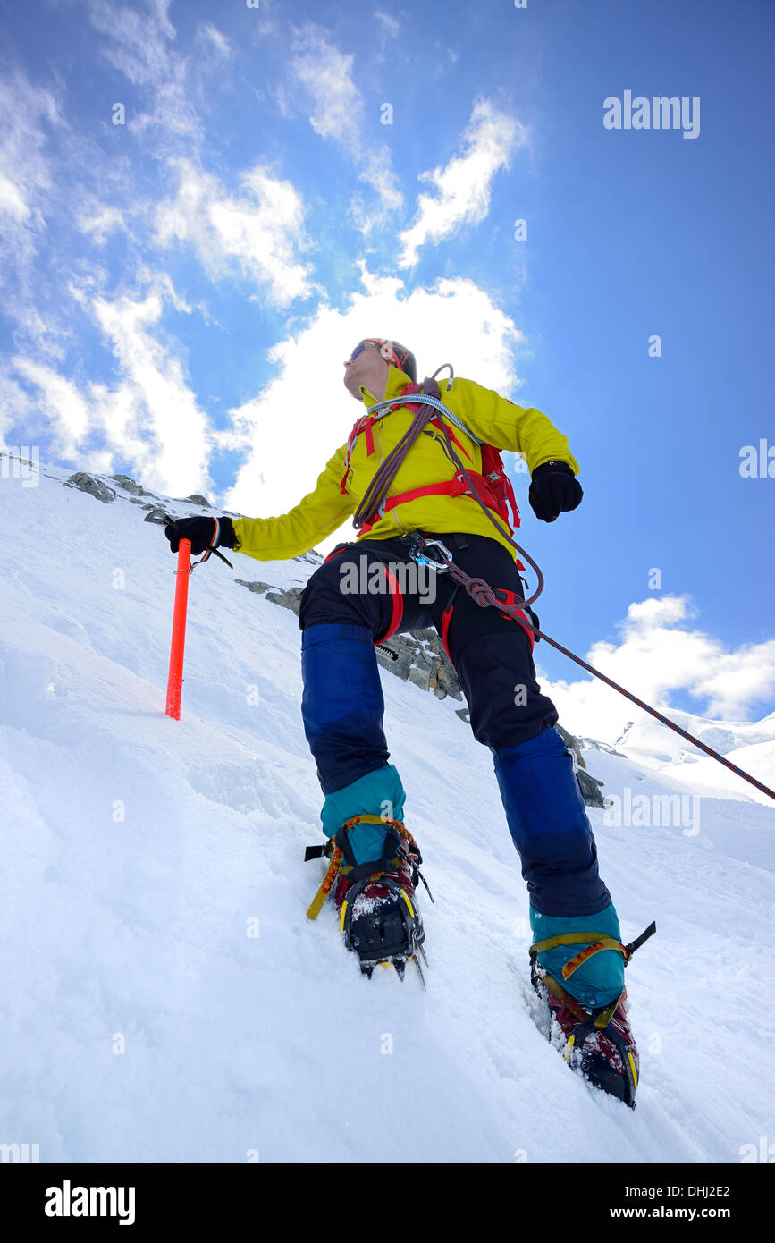 Mountaineer ascending with crampons and ice axe, Piz Palue, Grisons, Switzerland Stock Photo