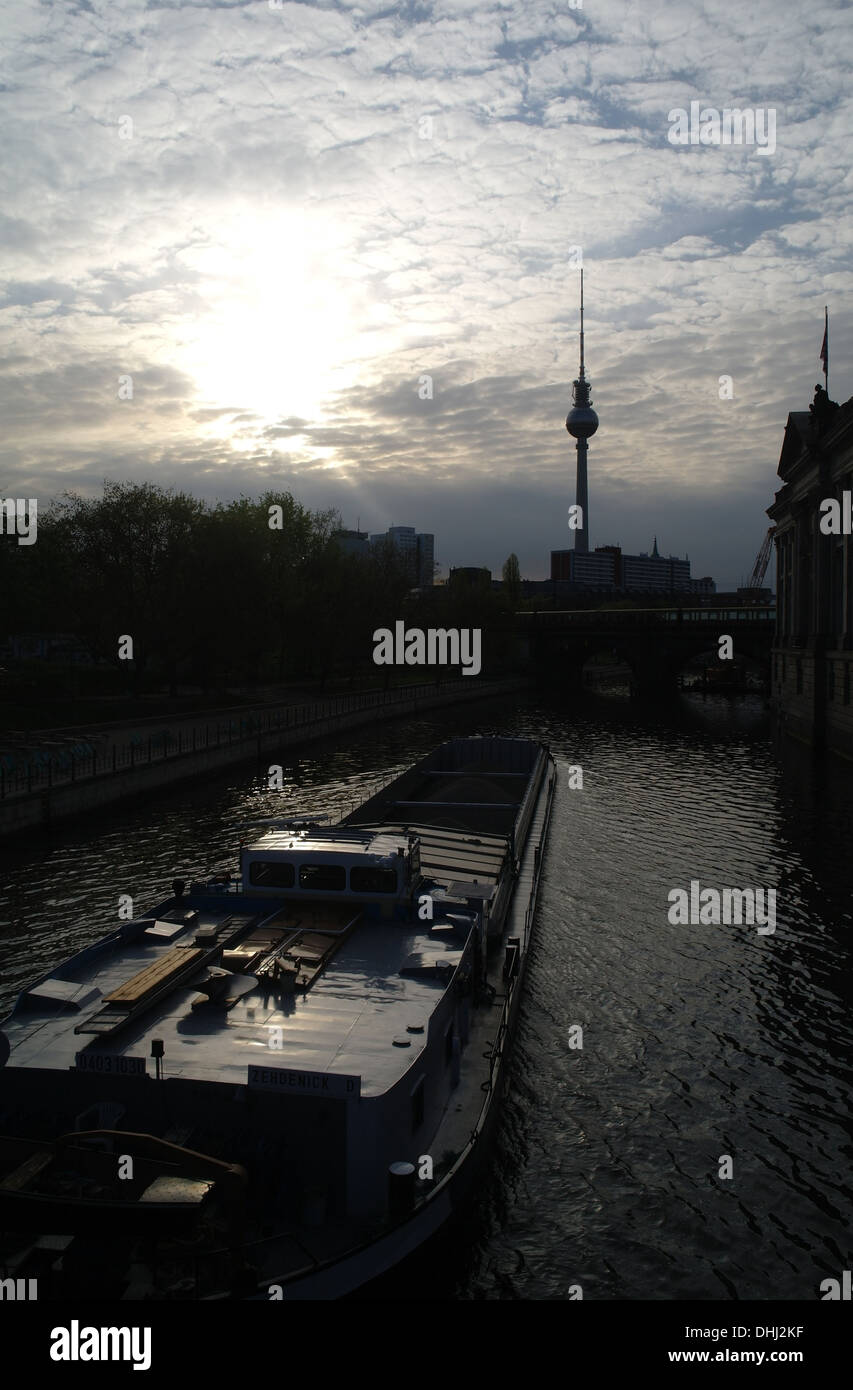 Sunrise mackerel sky portrait, to Alexanderplatz TV Tower from Monbijoubrucke, barge passing Bode Museum, River Spree, Berlin Stock Photo