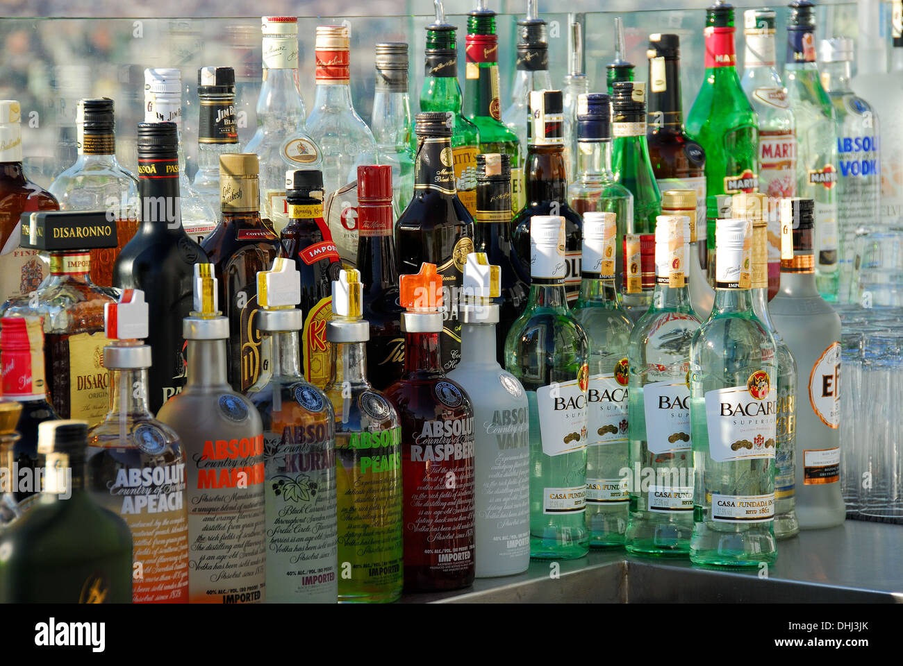 Lots of bottles of alcoholic spirits and liqueurs on a bar. Stock Photo