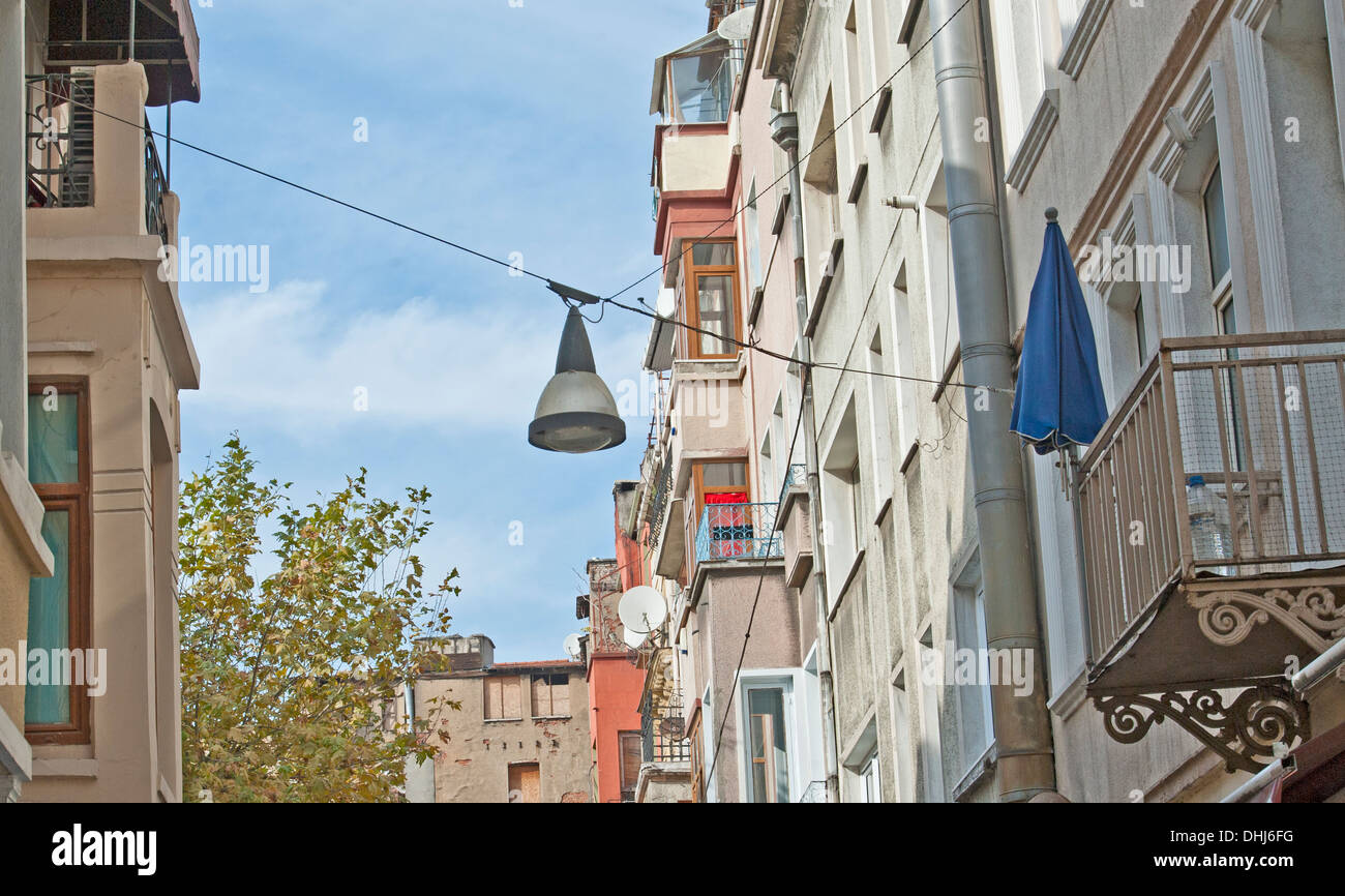 Building exteriors of city center apartment blocks on a narrow street with basic street lamp Stock Photo