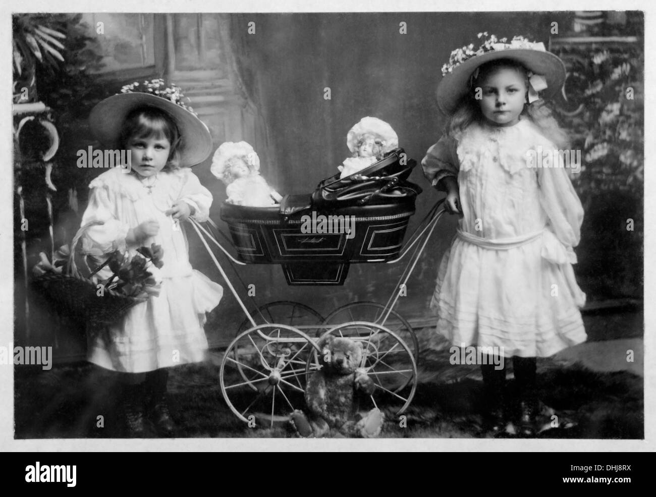 two victorian girls with pram and dolls - Historical Stock Photo