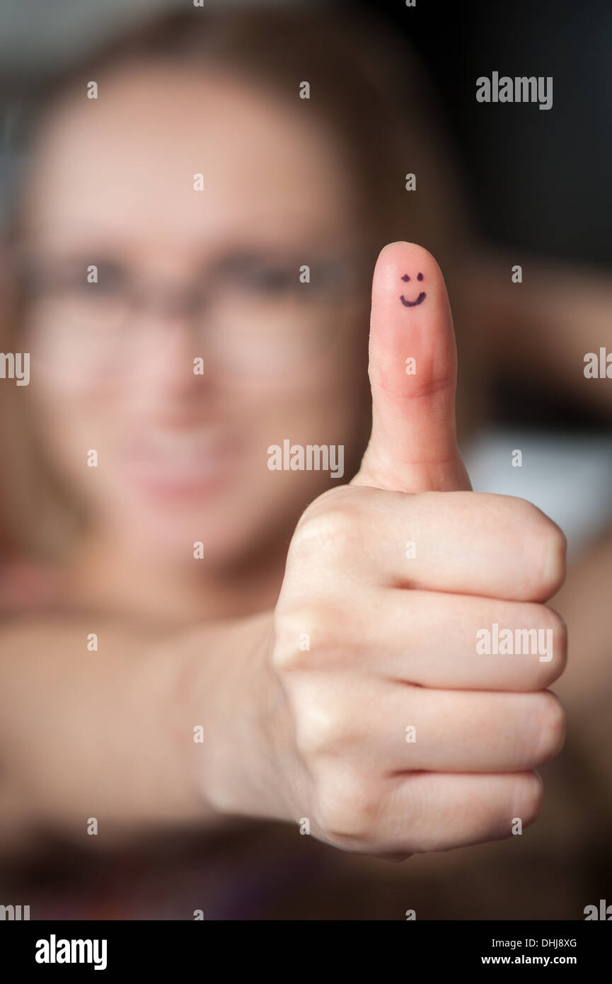Pretty woman with smiles on thumb giving thumbs up Stock Photo