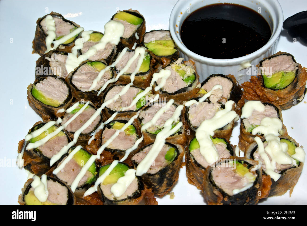 Deep fried battered nori seaweed wrapped albacore tuna avocado sushi slices wasabi mayo drizzle mirin soya sauce dip Stock Photo