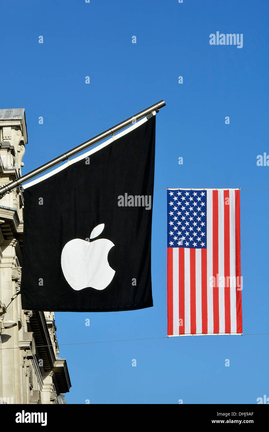 Flagpole with Apple logo flag & stars and stripes American Flag above Apple store entrance suspended across Regent Street  west end London England UK Stock Photo