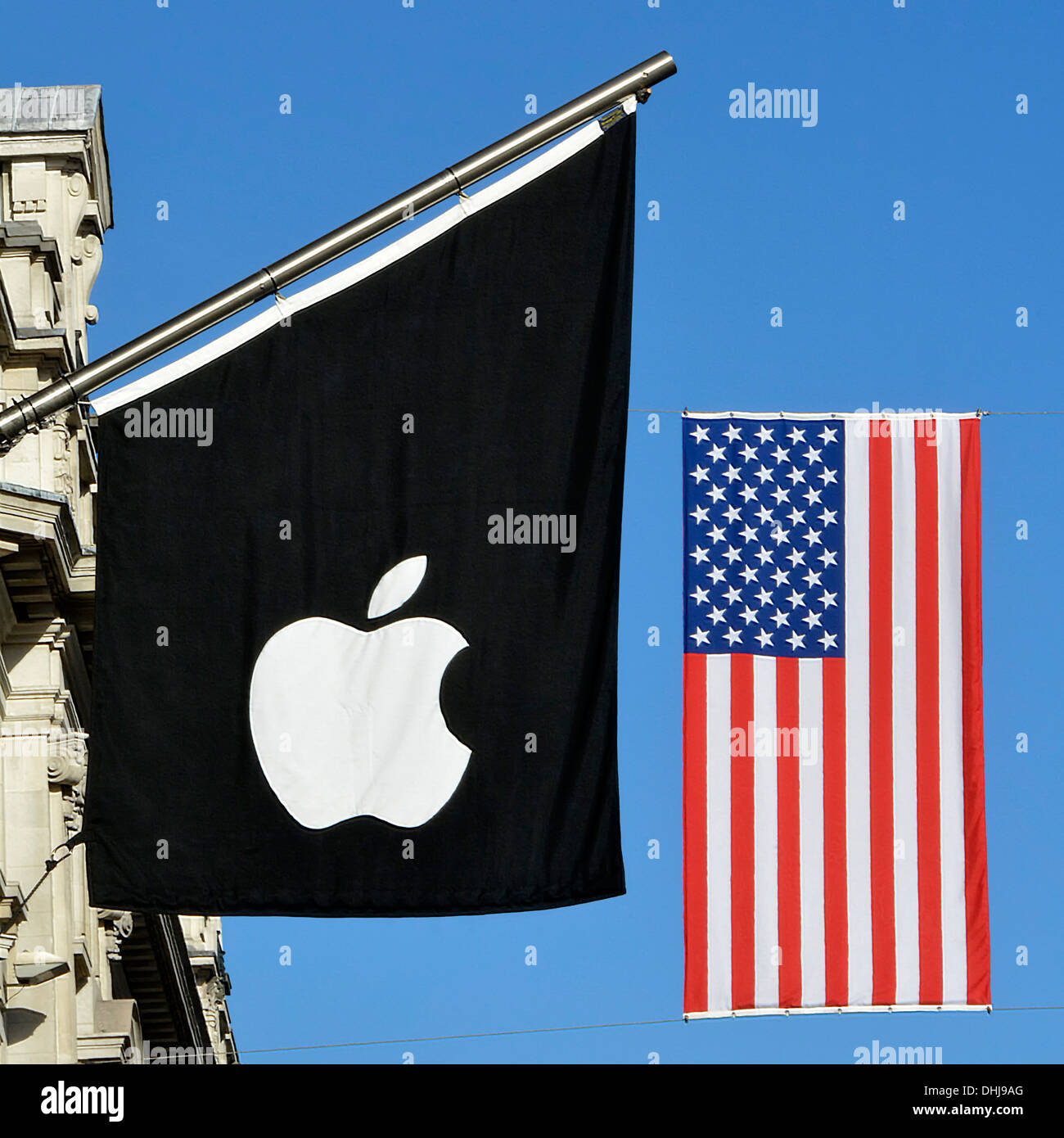Exterior of Apple store logo on flagpole & American flag suspended beyond on cables across Regents Street decorations for a London event England UK Stock Photo
