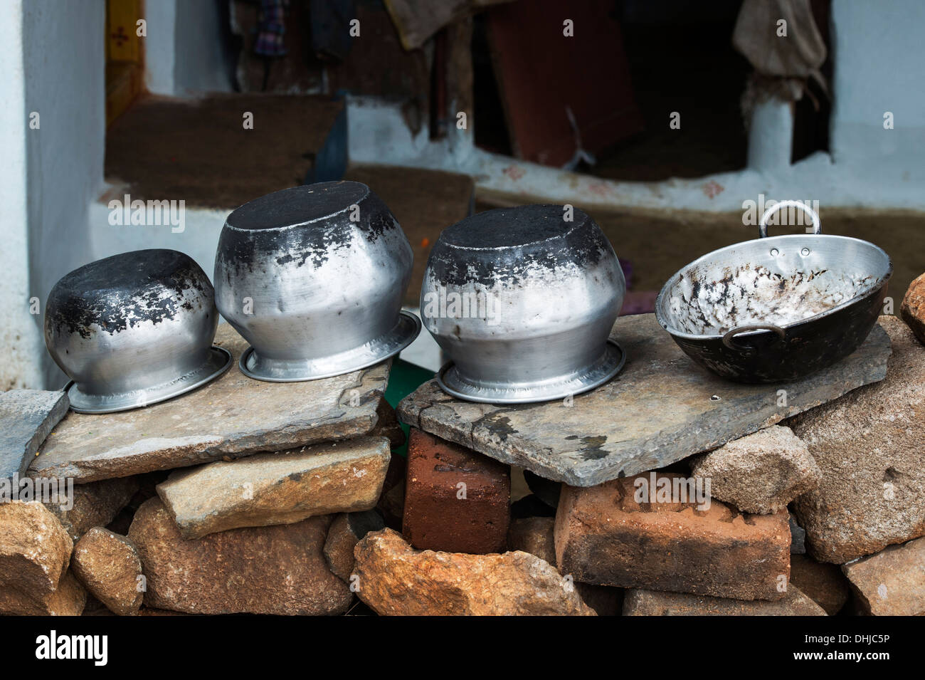 https://c8.alamy.com/comp/DHJC5P/indian-kitchen-cooking-pots-left-to-dry-outside-a-rural-indian-village-DHJC5P.jpg