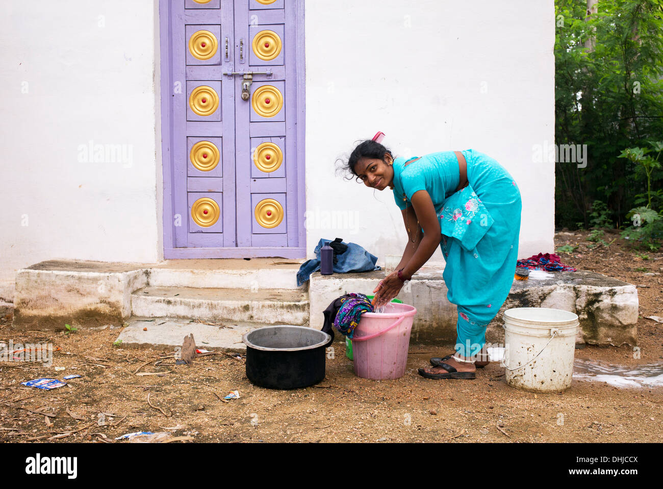 Indian woman washing clothes outside her home in a rural indian village. Andhra Pradesh, India Stock Photo