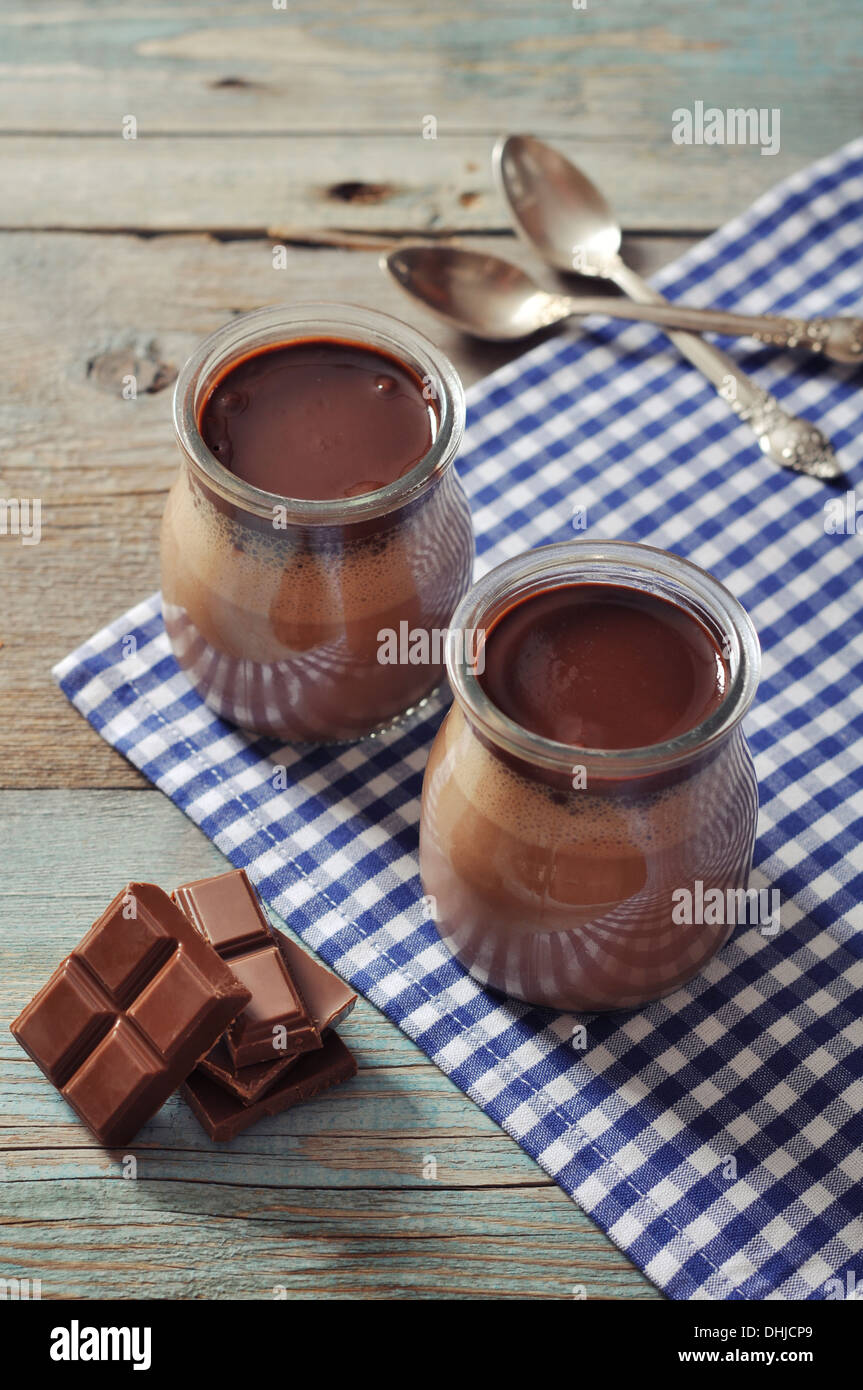 Chocolate dessert panna cotta in glass jars on wooden background Stock