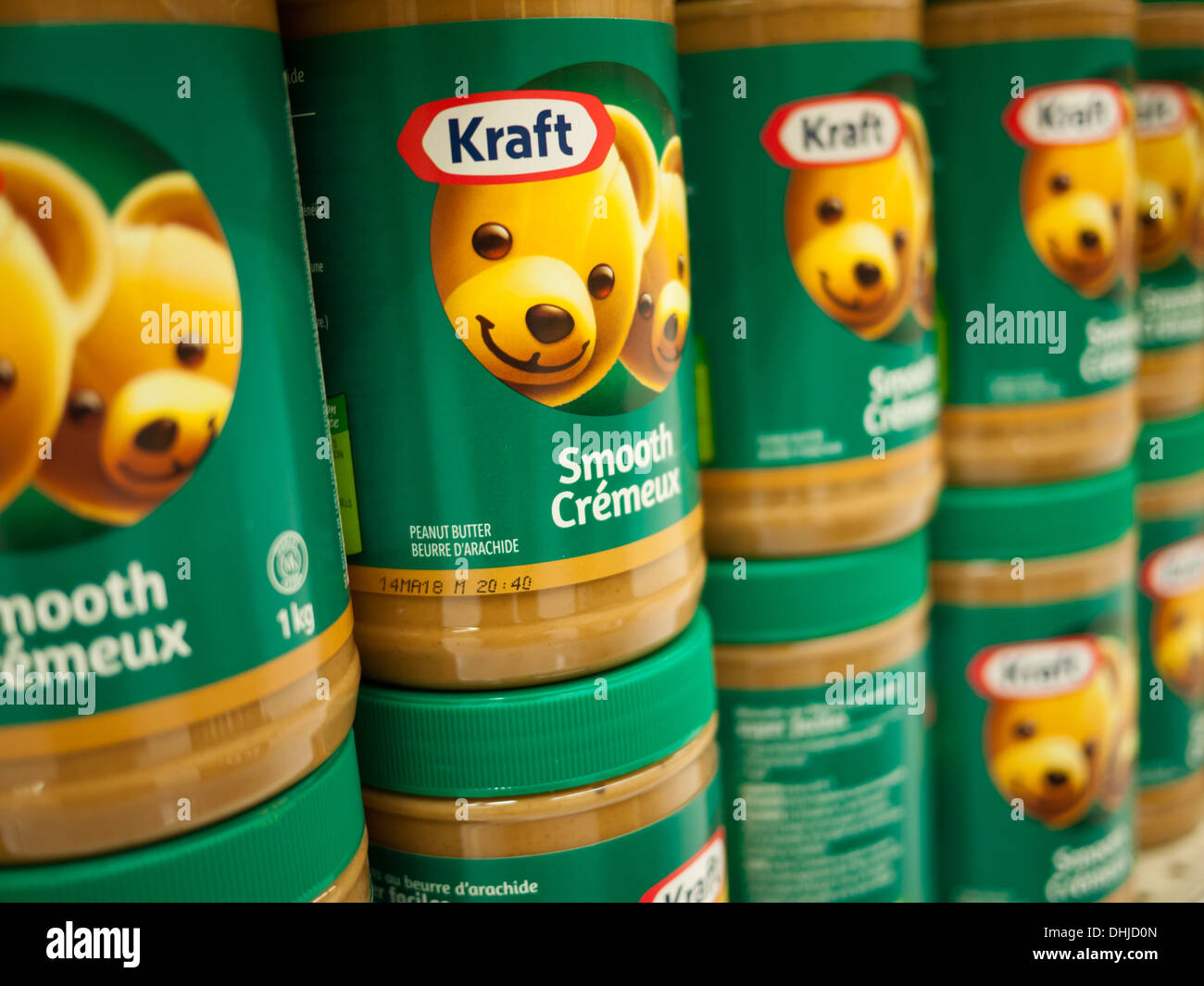 Jars of Kraft smooth peanut butter in a supermarket. Canadian English and French packaging is shown. Stock Photo