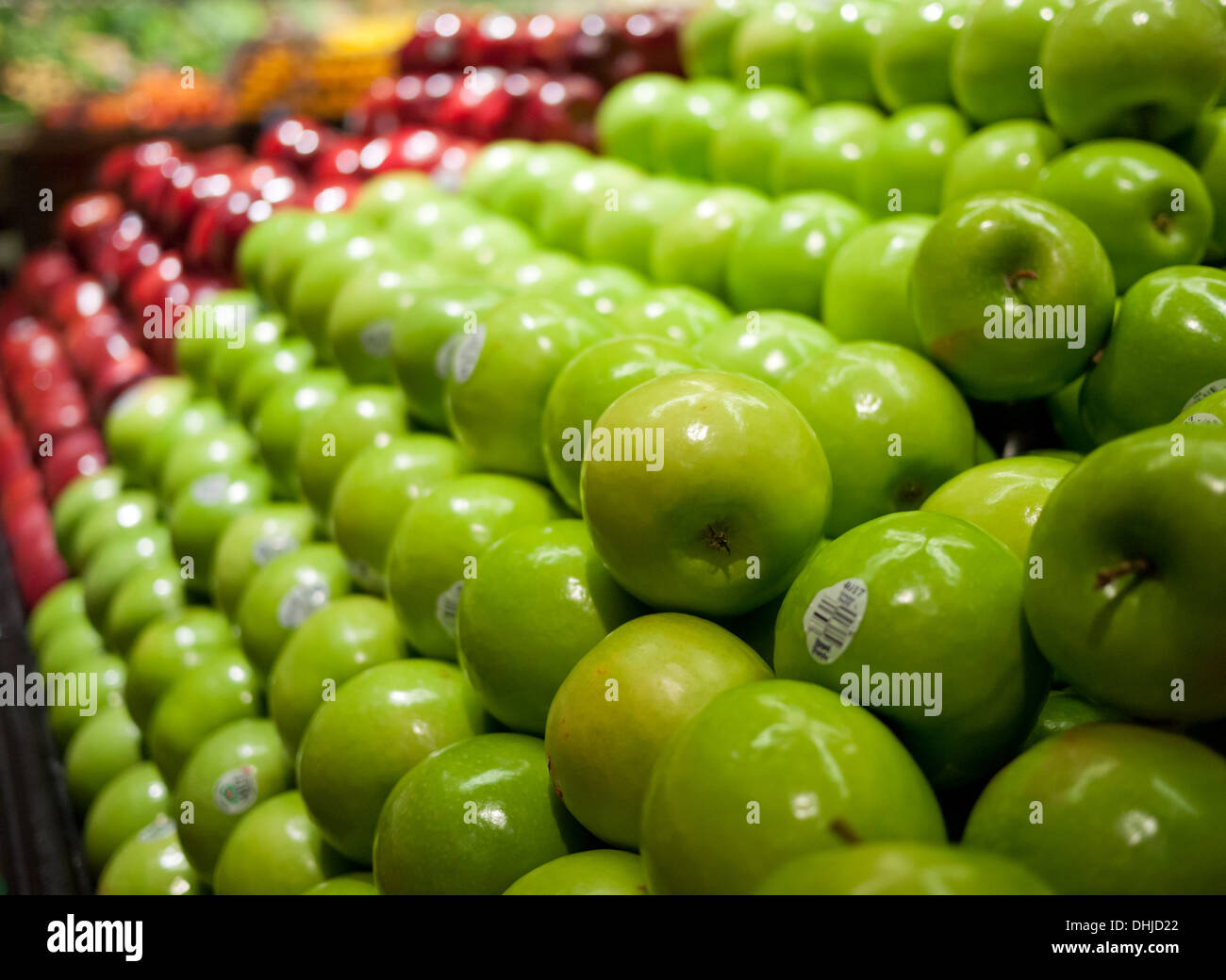 Green 'Granny Smith' apples in the foreground, red 'Red Delicious' apples in the background, in a grocery store. Stock Photo