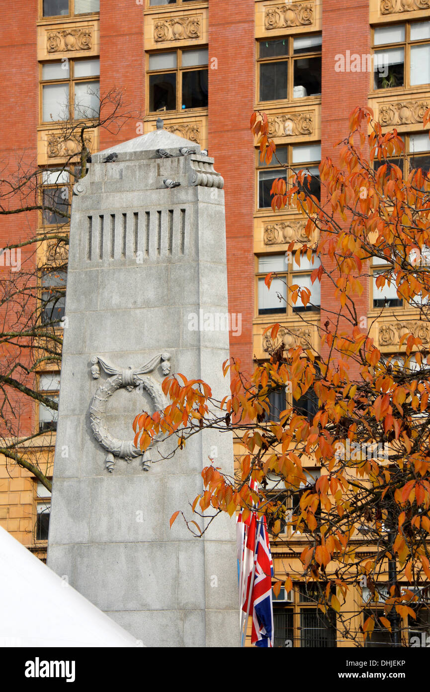 Canadian and British flags hang beside the Cenotaph draped at  Remembrance Day ceremonies in Victory Square in downtown Vancouver, British Columbia, Canada Stock Photo
