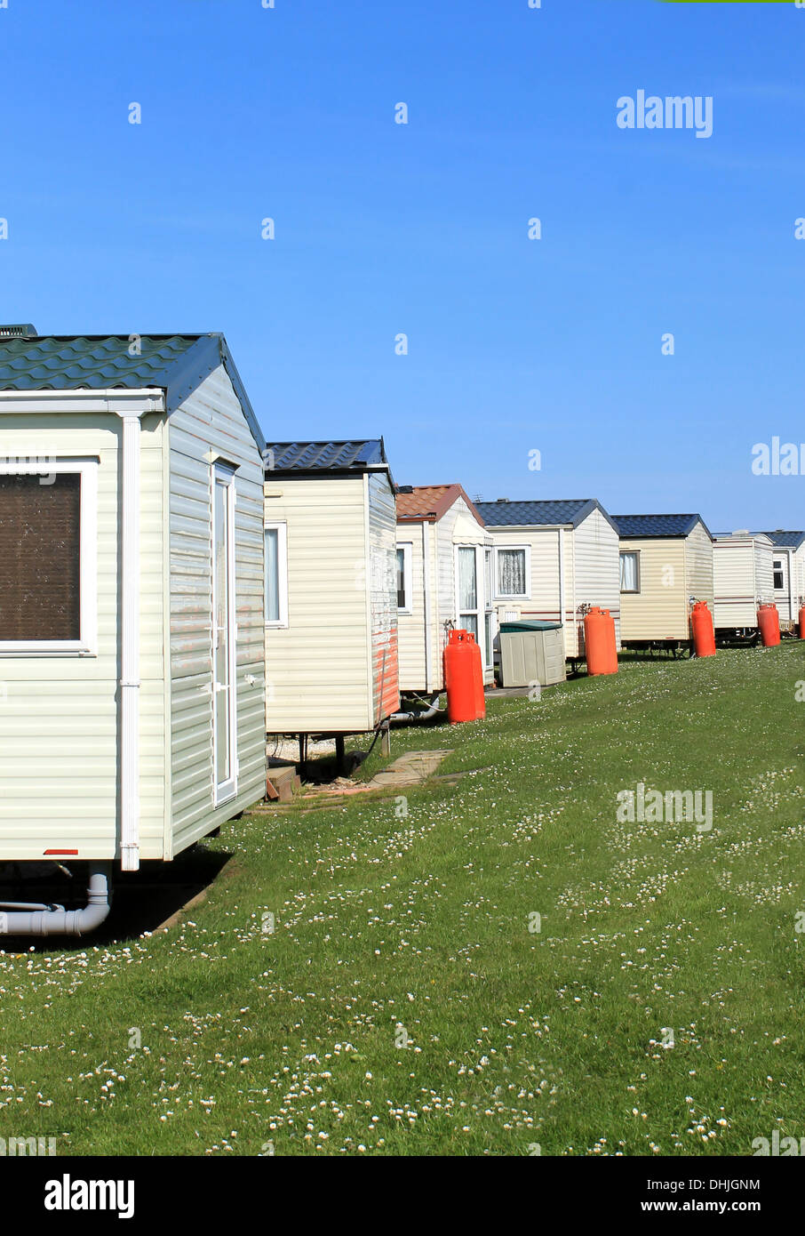 Scenic view of row of caravans in trailer park with blue sky background. Stock Photo
