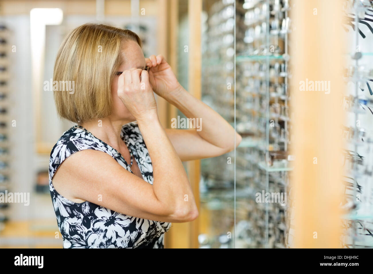 Woman Trying On Eyeglasses In Store Stock Photo