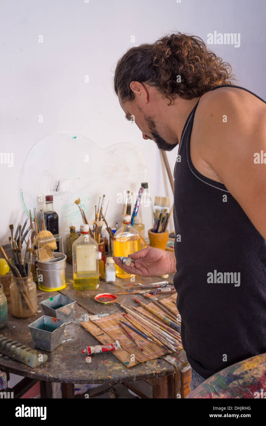 Long haired painter in a somewhat messy studio Stock Photo - Alamy