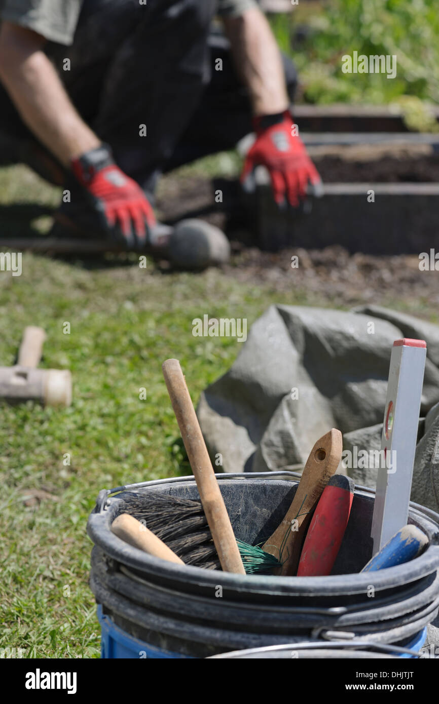 Stonemason working on a grave, tools for bricklaying and concreting