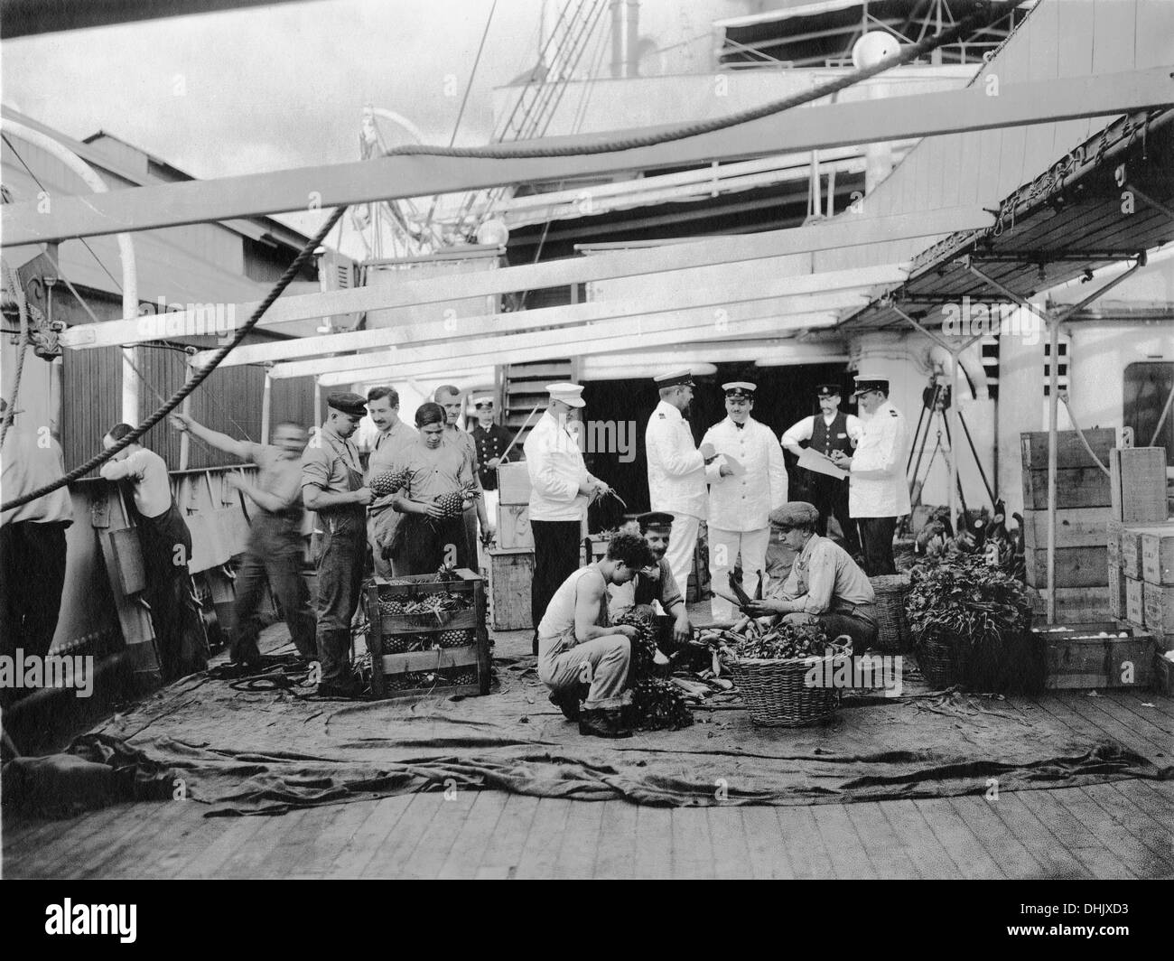 Food supplies are brought aboard an ocean liner ('Cleveland'?). Crew members examine pineapples, corn, and onions and check the list of deliveries, undate photograph (around 1911/1913). The image was taken by the German photographer Oswald Lübeck, one of the earliest representatives of travel photography and ship photography aboard passenger ships. Photo: Deutsche Fotothek/Oswald Lübeck Stock Photo