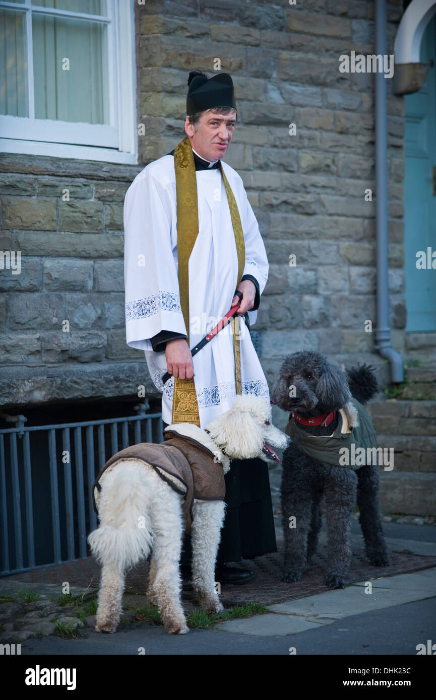 Vicar of St Mary's Church with his poodles on Remembrance Sunday parade in Hay-on-Wye Powys Wales UK Stock Photo