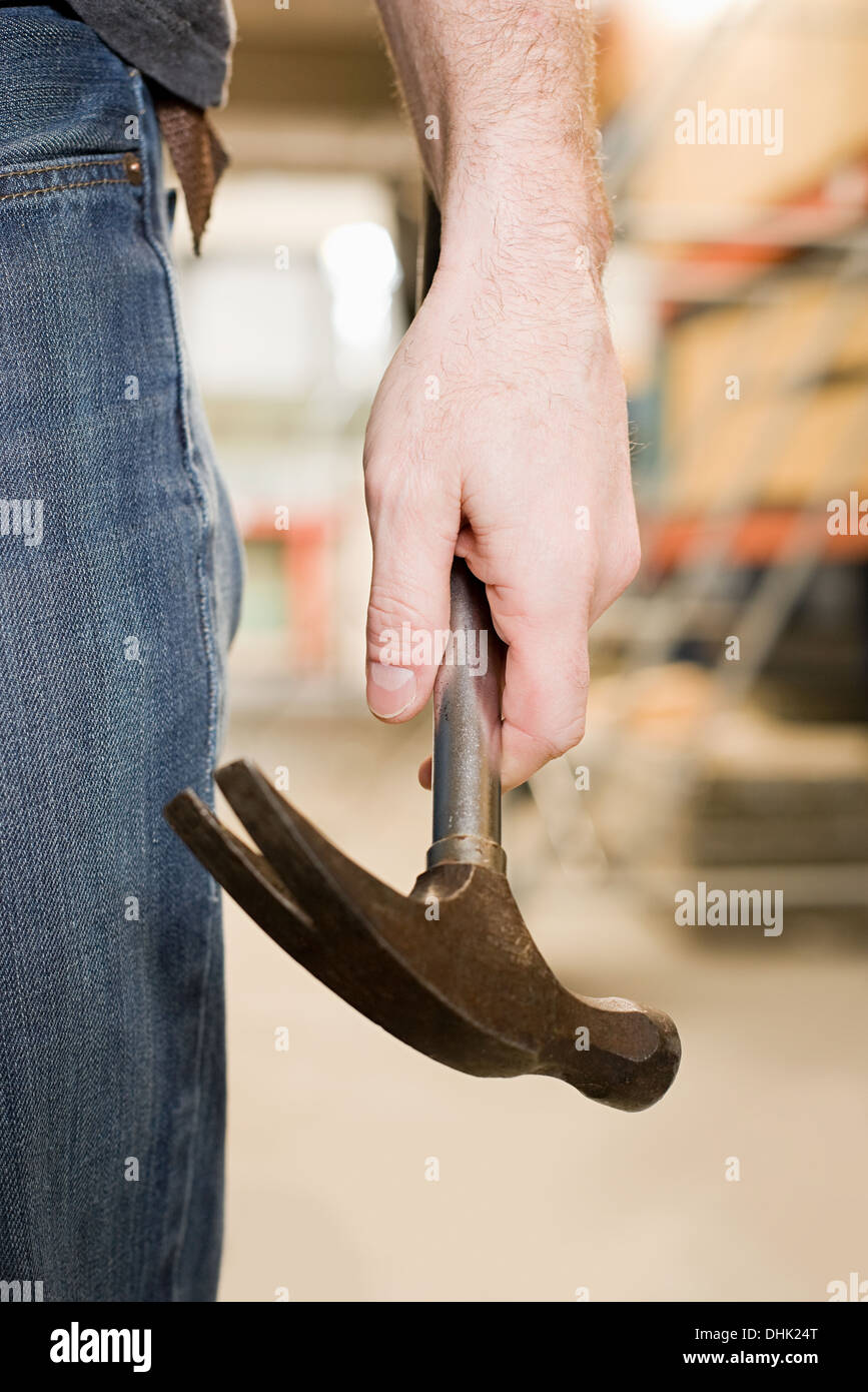 Person holding a hammer Stock Photo - Alamy