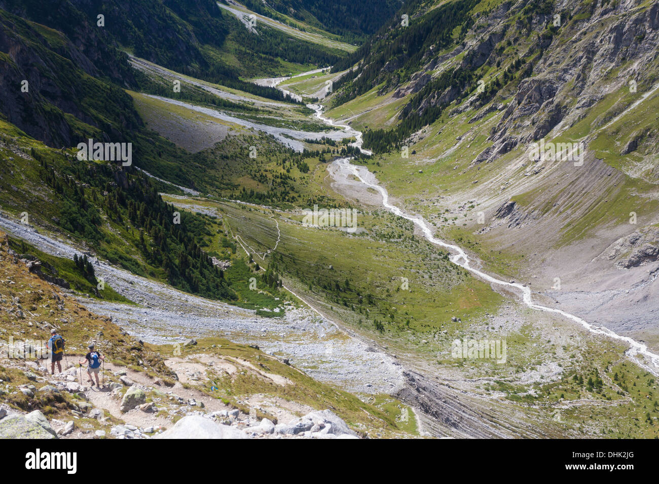 Two hikers, a man and a woman walking down to Gastern Valley, Bernese Oberland, Canton of Bern, Switzerland Stock Photo