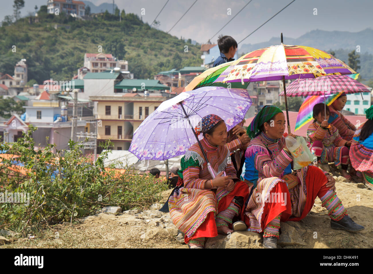 Young Vietnamese women at Bac Ha Market using umbrellas to shield themselves from the strong sun. Stock Photo