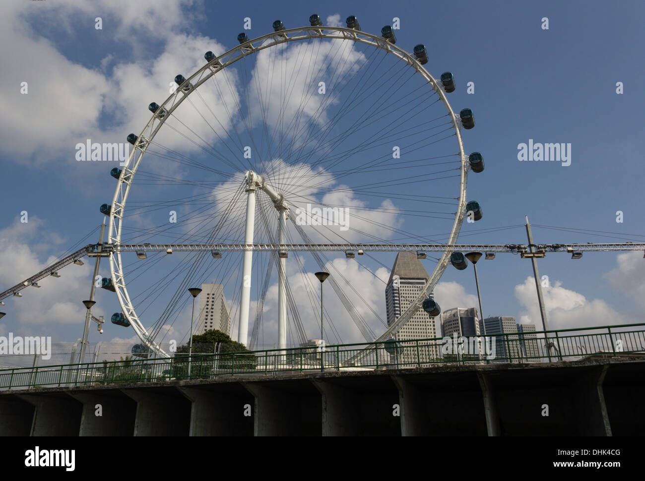 The circle of the Singapore Flyer along with preparation of Formula One race over a bridge. Lighting equipment for the race. Stock Photo