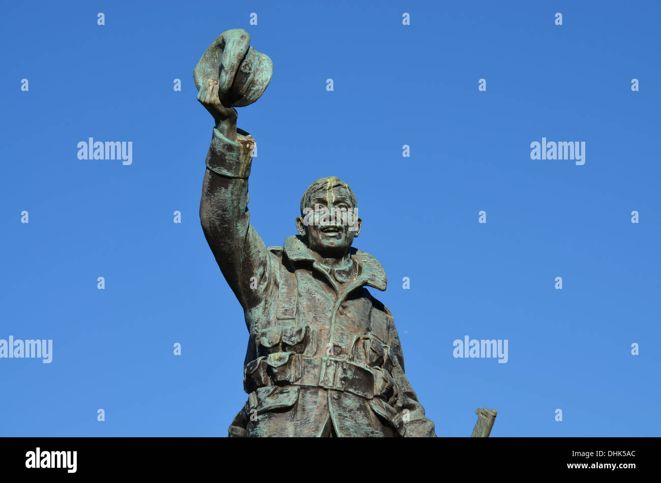 The soldier atop TwickenhamWarMemorial wears a smileas he waves through the silenceand the bandplaying thathave supported 100yrs Stock Photo